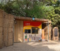 Entrance to Hatta Adventures building with a red-yellow mural, wooden slat walls, and a blue '2' sign